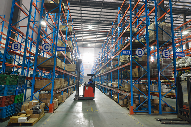 Storage racks and a pallet truck in a warehouse aisle